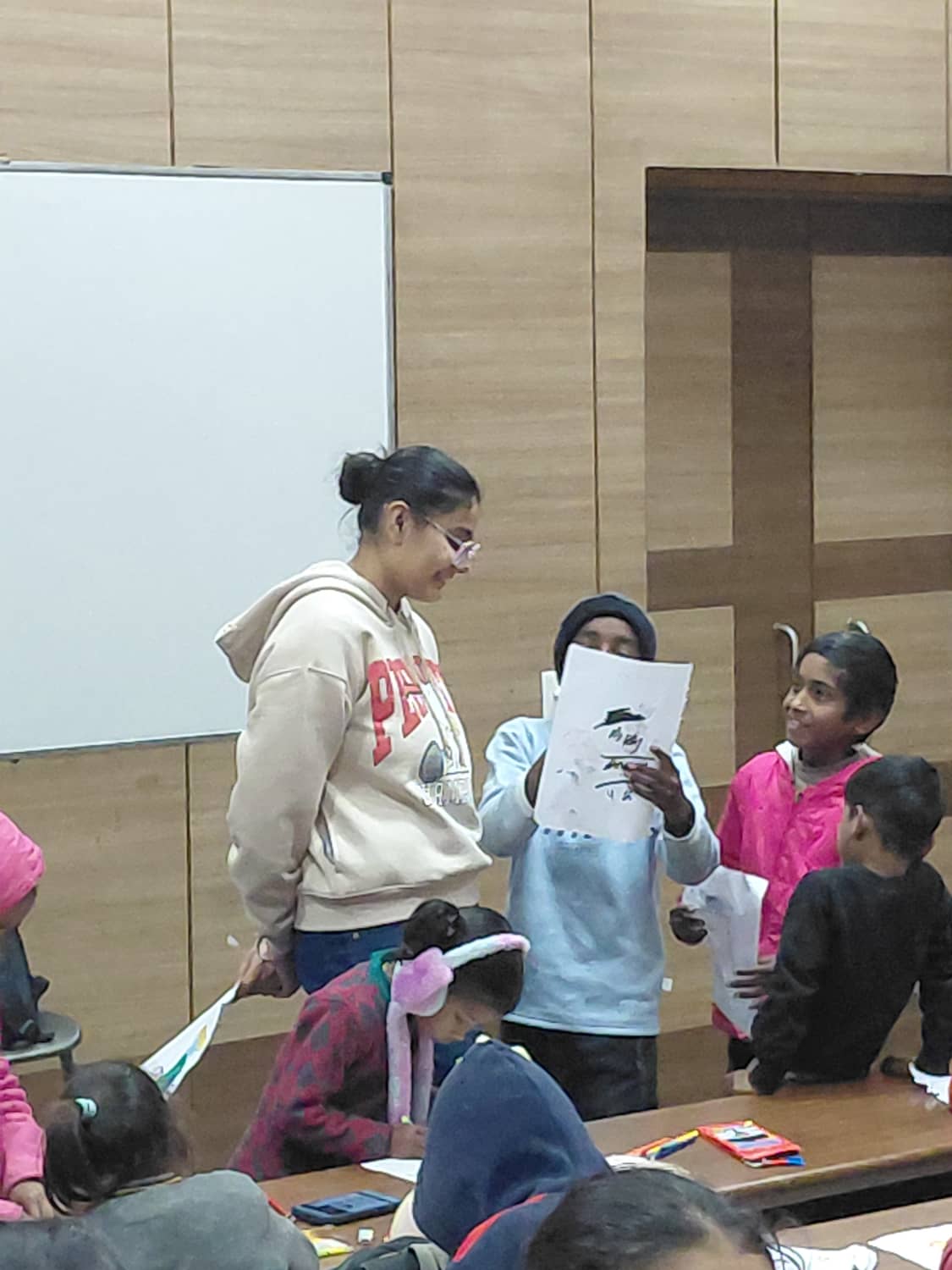 Triman listening to a child share their work in a classroom
